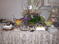 Table with fruits cakes and silverware